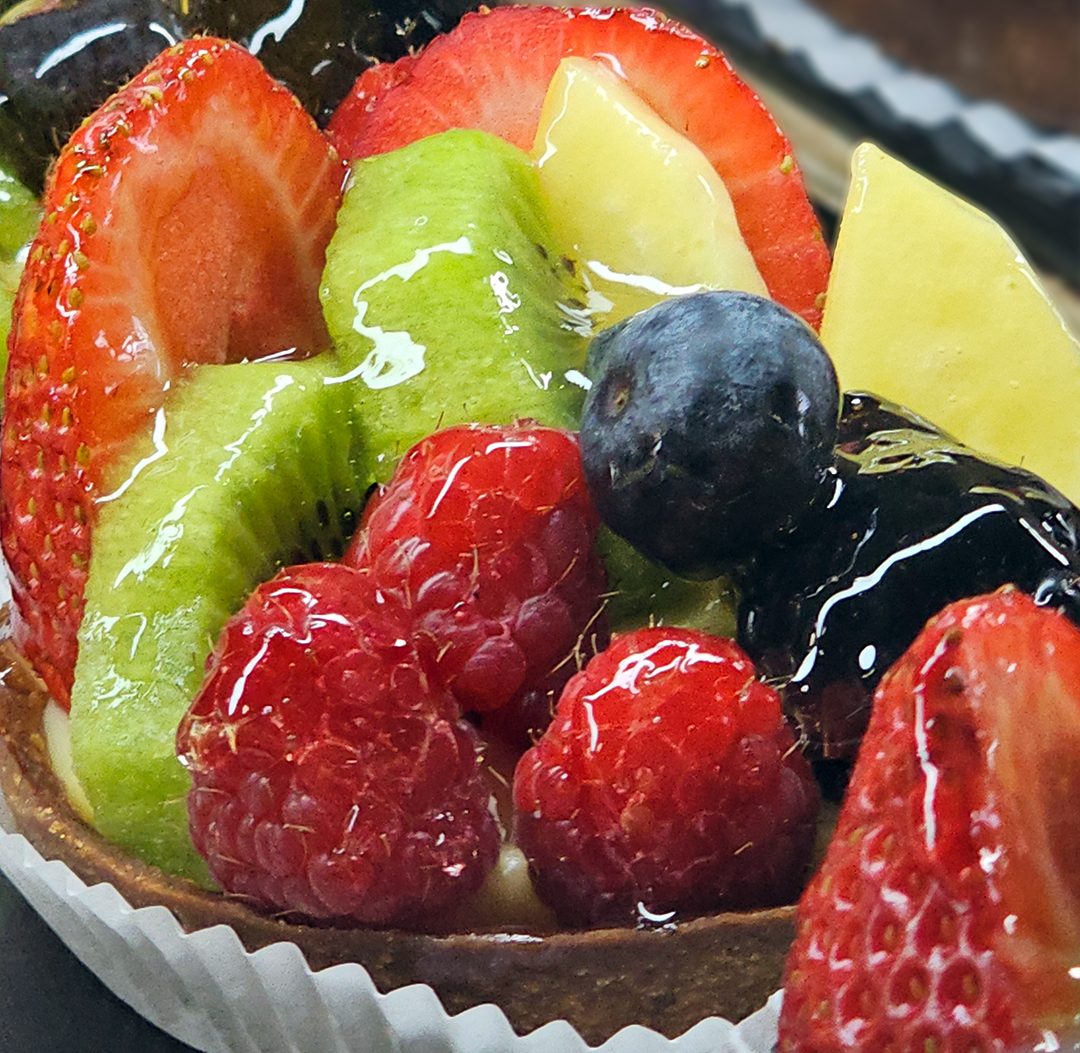 A bright fruit tart with strawberry, kiwi, mango and raspberry from the La Sucrière pâtisserie case